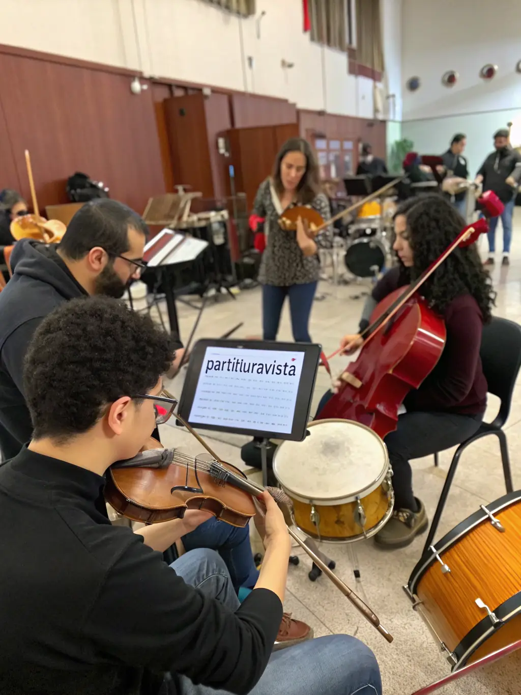 A picture of a music ensemble rehearsing, featuring musicians playing diverse instruments, illustrating GOURBI PRODUCTIONS' commitment to supporting musical talent and cultural exchange.